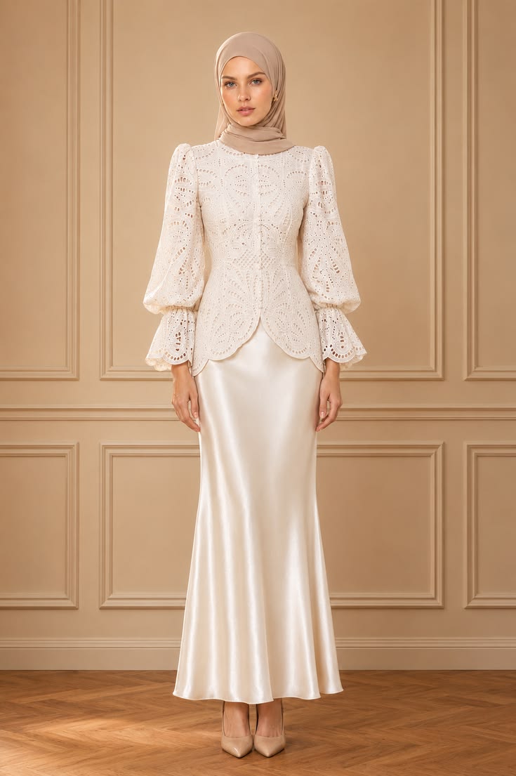 Romantic modest wedding guest outfit with a broderie anglaise blouse, balloon sleeves, ivory satin maxi skirt, taupe hijab, and nude heels.